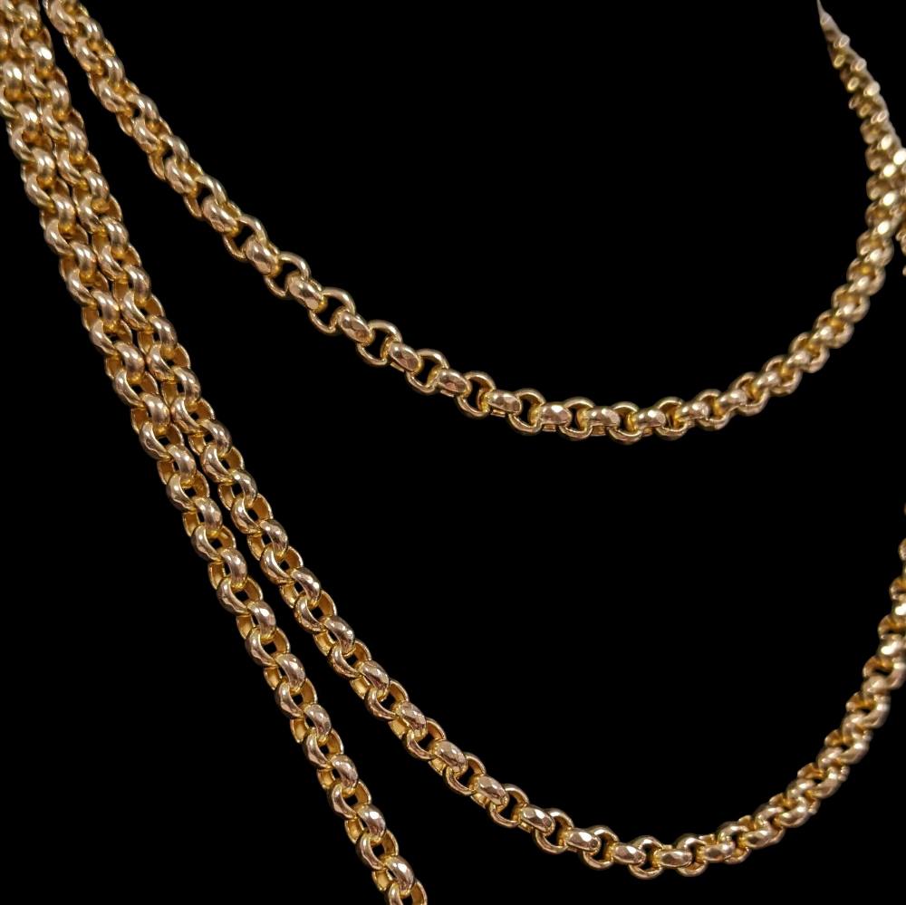 Two gold chain necklaces draped on a black background.