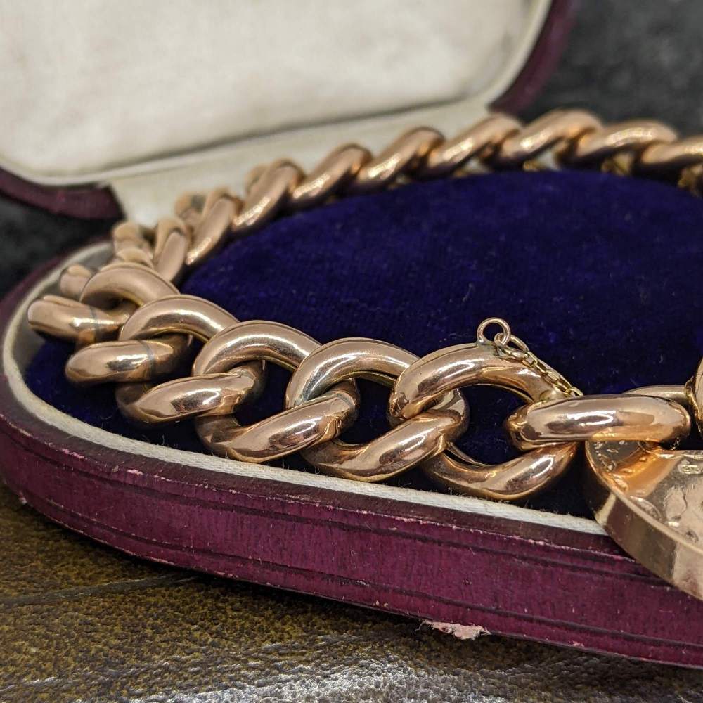 Gold-tone chunky chain bracelet resting in a purple velvet jewelry box.